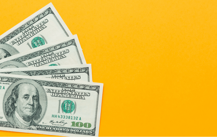 Several hundred-dollar bills fanned out against a bright yellow background.