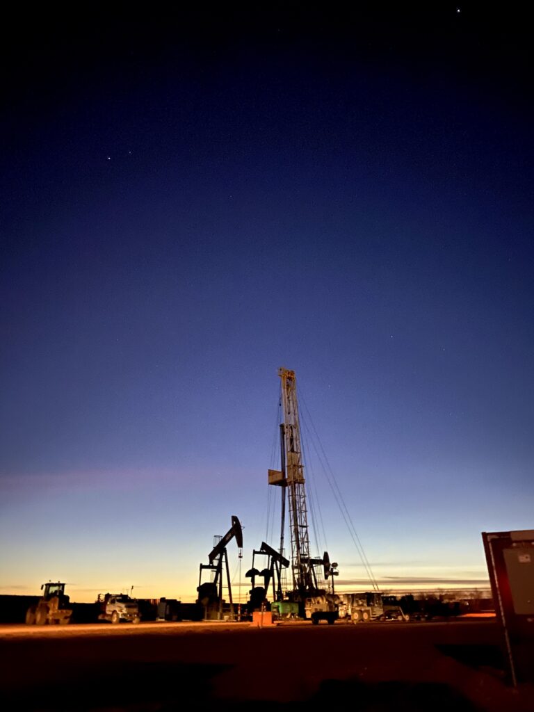 Oil drilling rig silhouetted against a twilight sky.